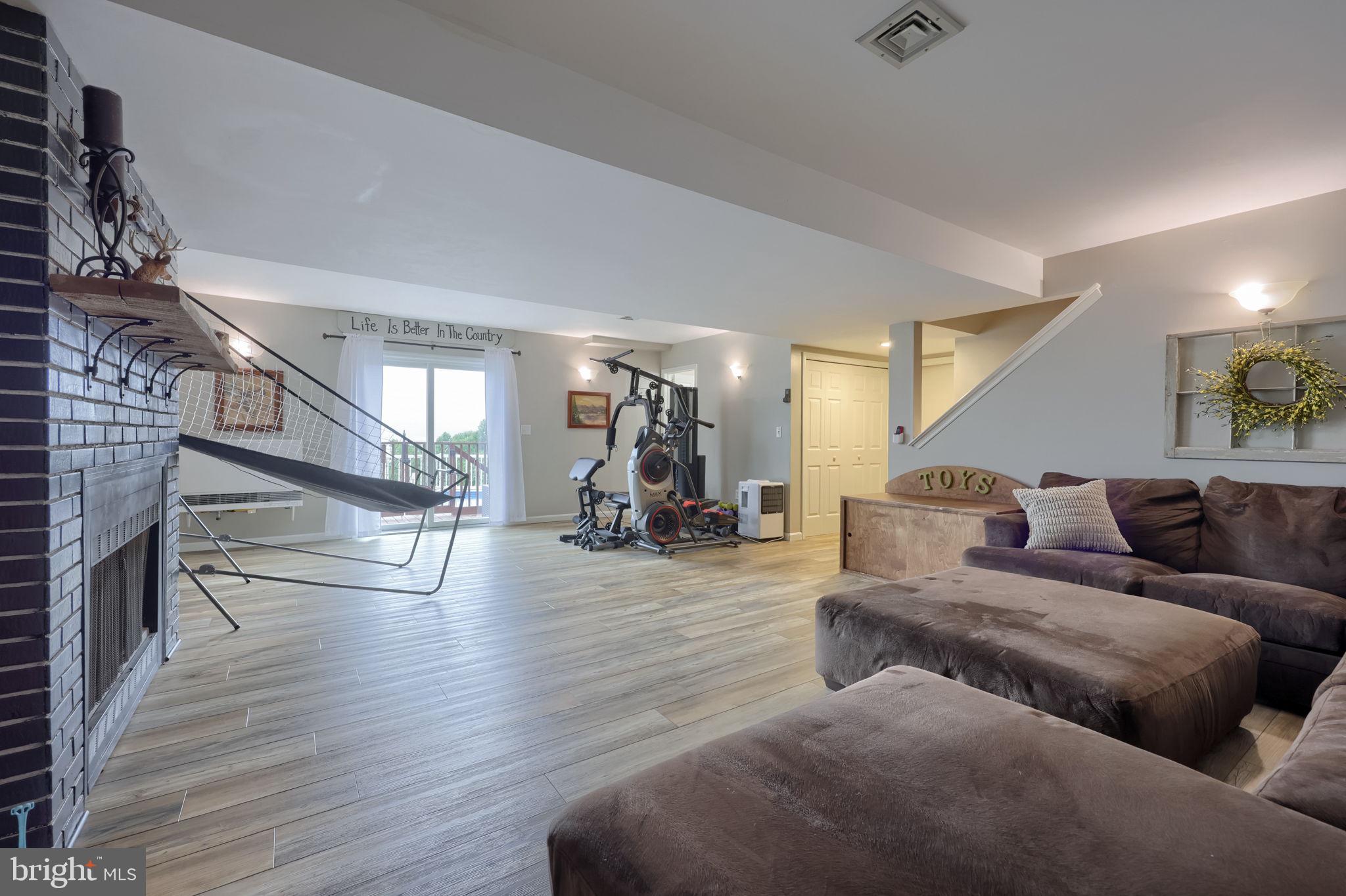 479 Hilldale Road Holtwood, PA 17532 - Photo 18 of 51 a living room with couches and a dining table with wooden floor