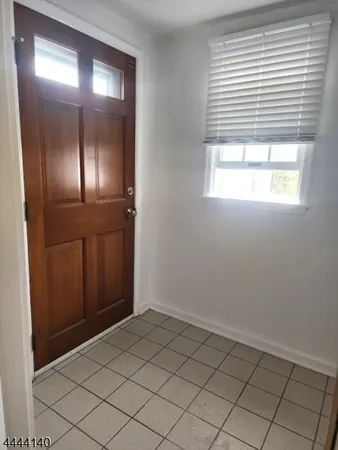 an empty room with wooden floor and mirror in closet