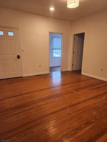 an empty room with wooden floor and closet