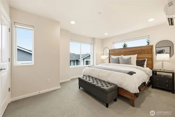 a bedroom with a bed lamp and a large window