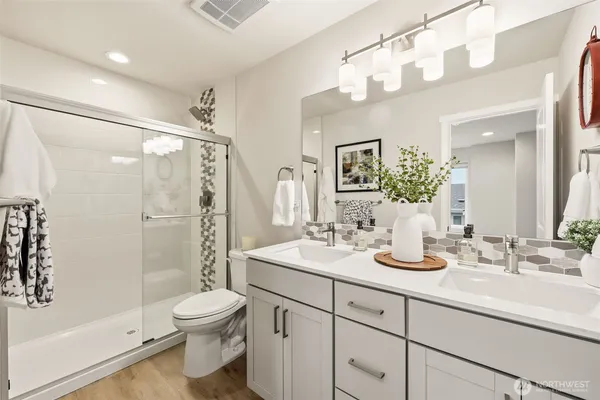 a bathroom with a sink a toilet and shower