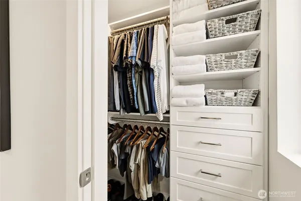 a view of walk in closet with clothes and shoes