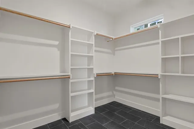 a view of walk in closet with empty racks