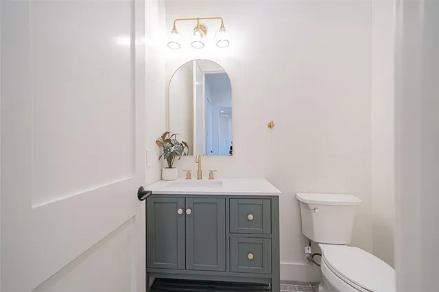 a bathroom with a toilet a sink and mirror