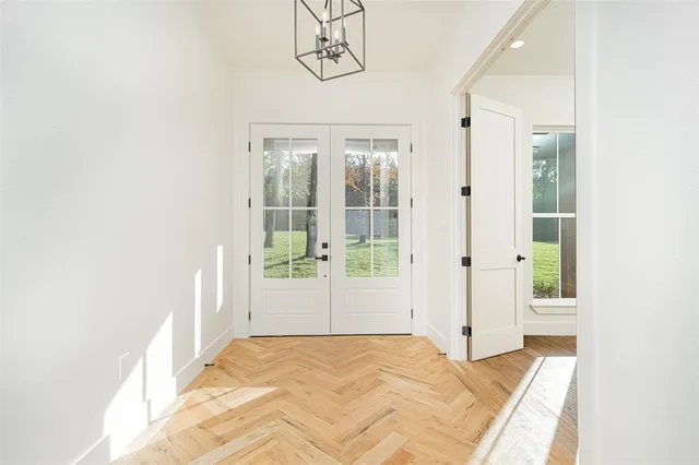 a view of a hallway with wooden floor and cabinet