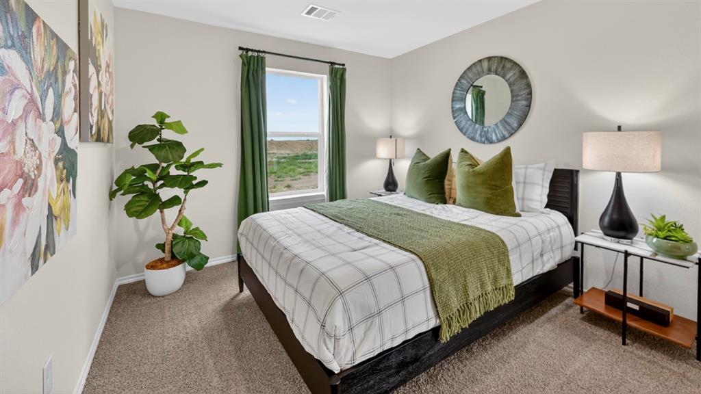 3514 Spring Time Street Terrell, TX 75126 - Photo 15 of 26 Spacious bedroom featuring neutral wall tones, carpeted flooring, a large window with green drapery, and a textured circular wall mirror