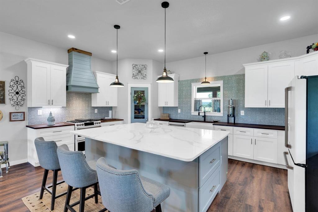 1467 Brown Road Palo Pinto, TX 76484 - Photo 14 of 38 a kitchen with stainless steel appliances granite countertop a sink a stove a refrigerator and white cabinets