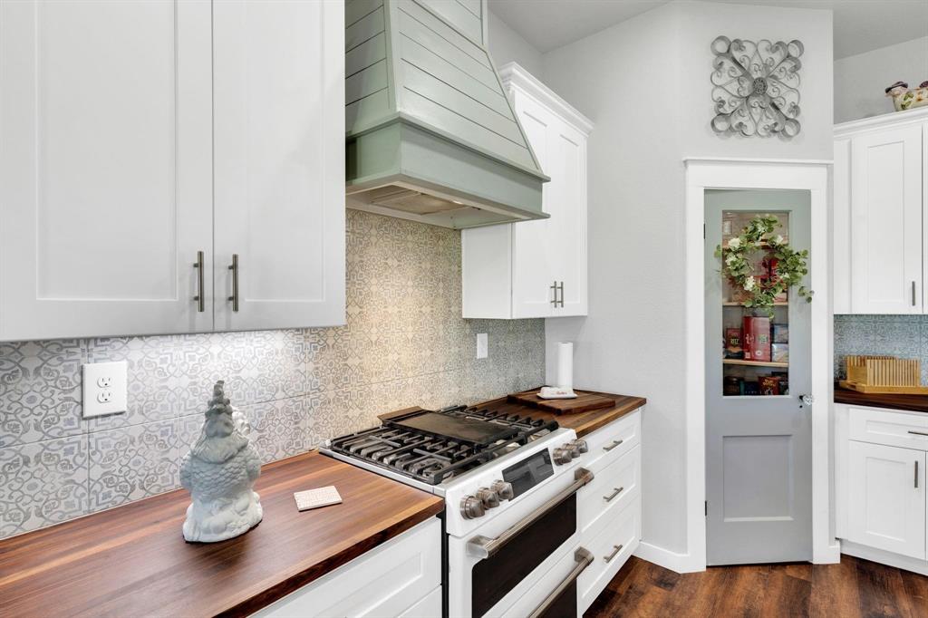 1467 Brown Road Palo Pinto, TX 76484 - Photo 16 of 38 a kitchen with stainless steel appliances granite countertop a stove and a wooden cabinets