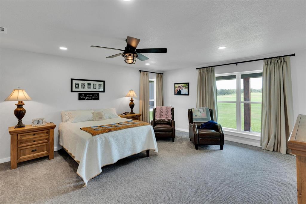 1467 Brown Road Palo Pinto, TX 76484 - Photo 24 of 38 a bedroom with a bed and a chandelier