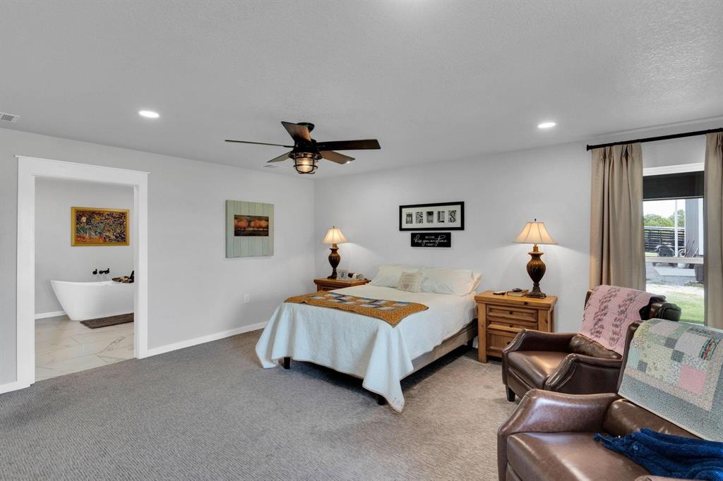 1467 Brown Road Palo Pinto, TX 76484 - Photo 26 of 38 a bedroom with a bed and a chandelier