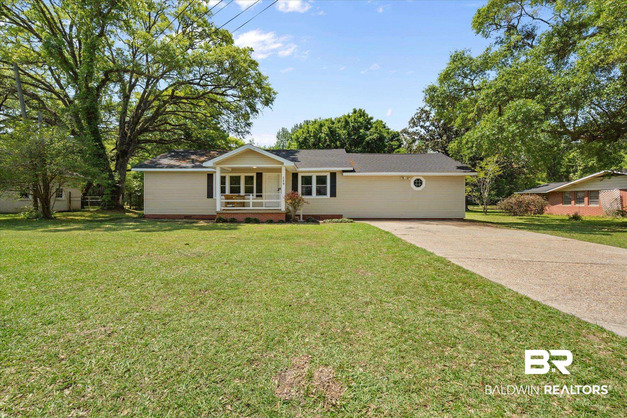 529 Cleveland Road Saraland, AL 36571 - Photo 29 of 31 Ranch-style home with a front lawn, concrete driveway, and covered porch