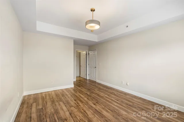 a view of a room with wooden floor and a ceiling fan