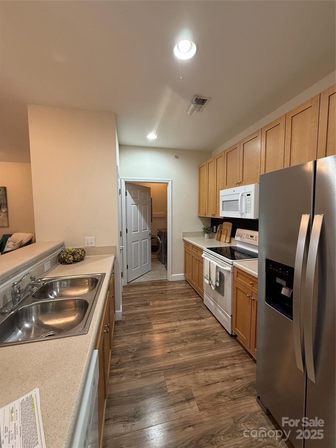 3805 Balsam Street, Unit 321 Indian Trail, NC 28079 - Photo 44 of 47 a kitchen with stainless steel appliances granite countertop a refrigerator a stove and a sink with wooden floor