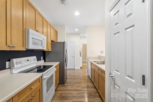 a kitchen with a refrigerator a sink and wooden cabinets