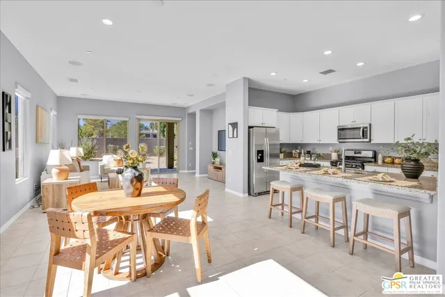 a kitchen with stainless steel appliances kitchen island granite countertop a table and chairs