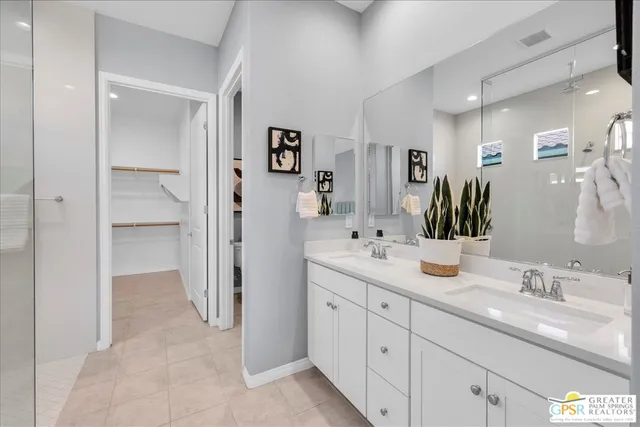 a en suite bathroom with double sink and a mirror