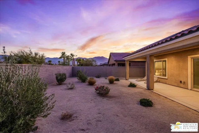 a backyard of a house with table and chairs