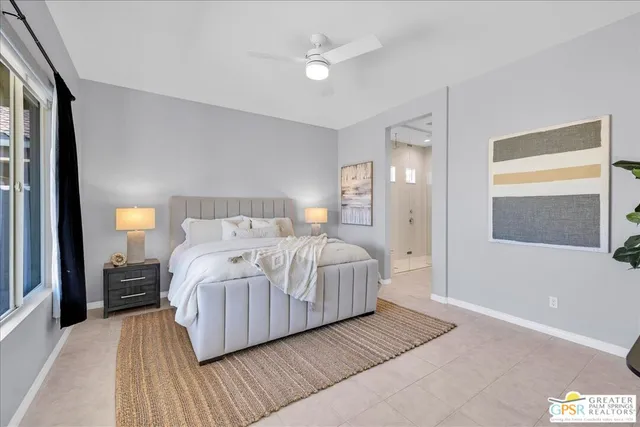 a bedroom with a large bed chandelier and a window