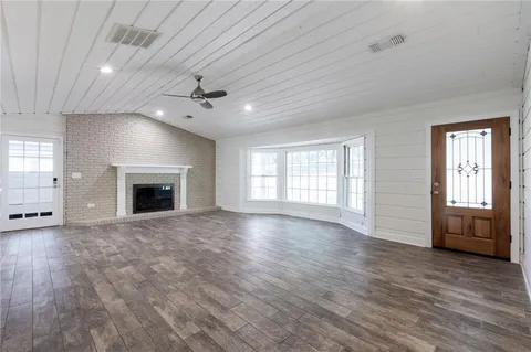 an empty room with windows and a fireplace