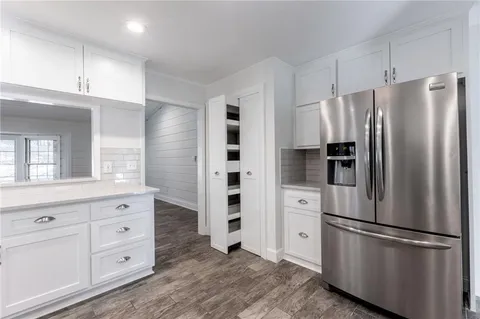 a kitchen with white cabinets and stainless steel appliances