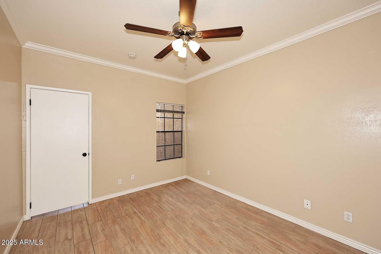 1126 West Elliot Road, Unit 1040 Chandler, AZ 85224 - Photo 16 of 25 an empty room with wooden floor chandelier fan and windows