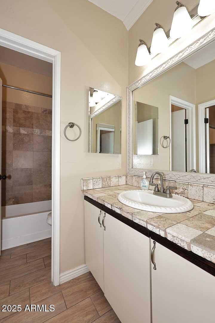 1126 West Elliot Road, Unit 1040 Chandler, AZ 85224 - Photo 20 of 25 a bathroom with a granite countertop sink a mirror and a shower