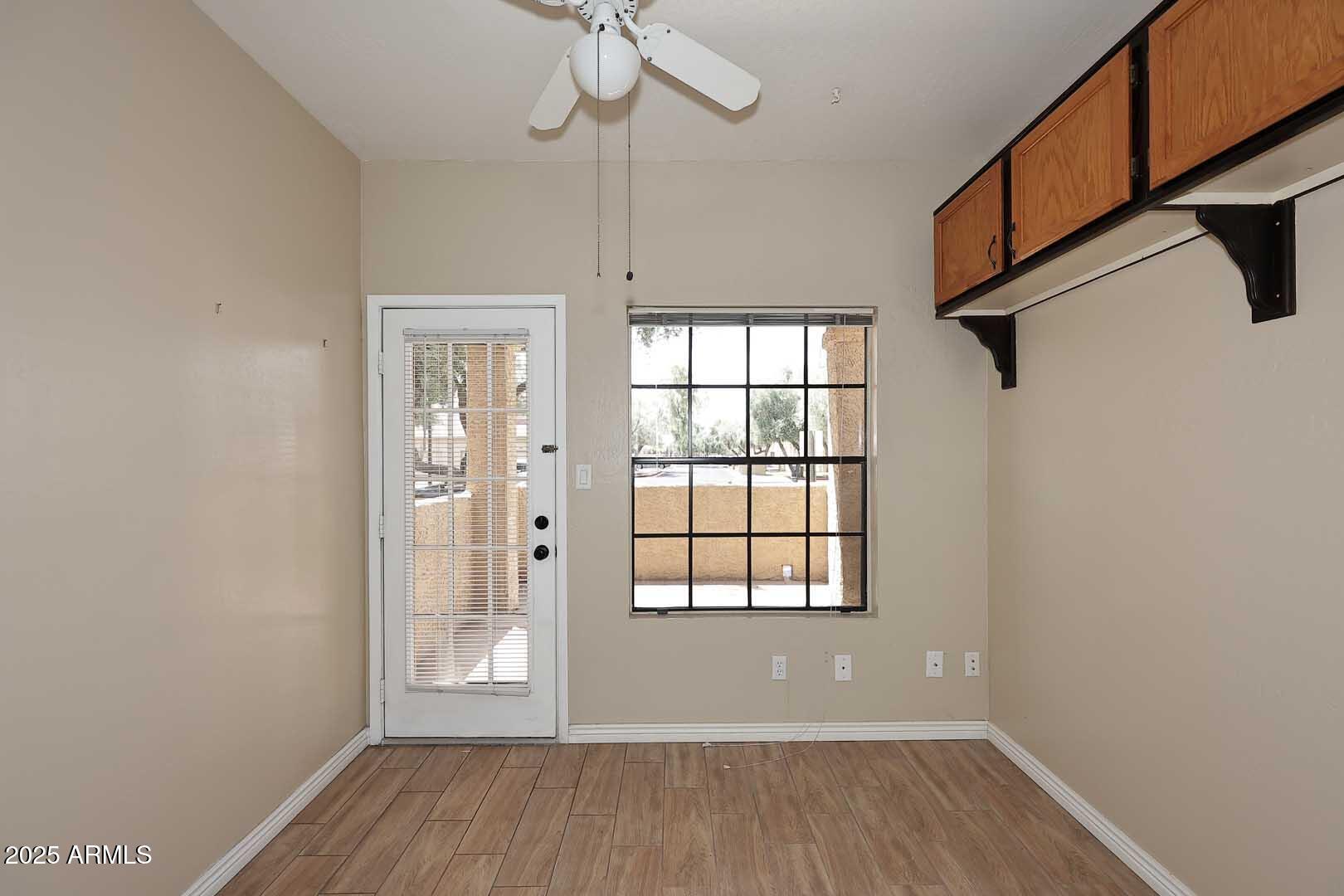1126 West Elliot Road, Unit 1040 Chandler, AZ 85224 - Photo 22 of 25 an empty room with wooden floor fan and windows