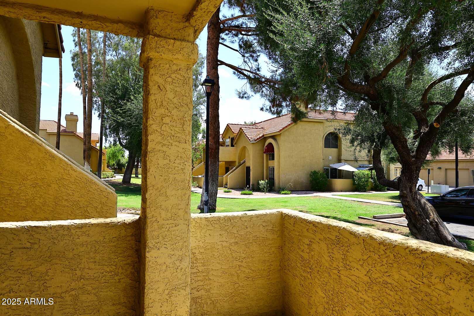 1126 West Elliot Road, Unit 1040 Chandler, AZ 85224 - Photo 24 of 25 a view of a house with a big yard and large tree