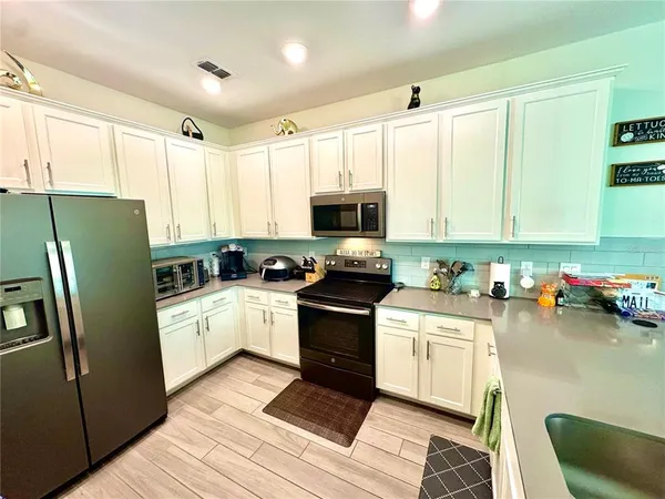 a kitchen with a sink a refrigerator and cabinets