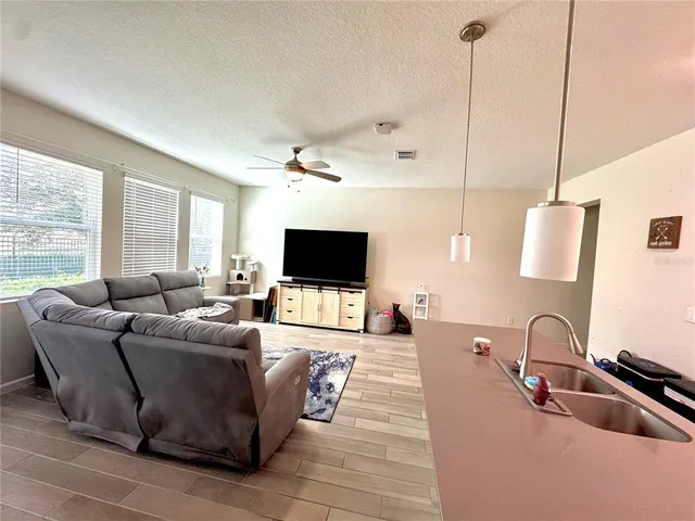a living room with furniture a flat screen tv and a large window