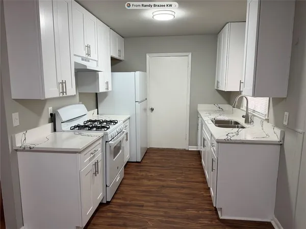 a kitchen with granite countertop a sink stove and cabinets