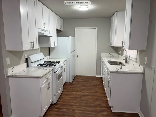 a kitchen with granite countertop a sink stove and cabinets