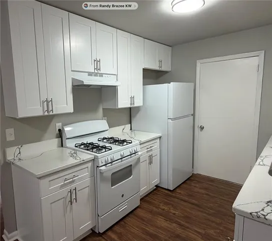 a kitchen with a sink stove top oven and cabinets