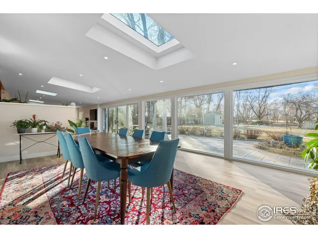 a dining room with furniture and a floor to ceiling window