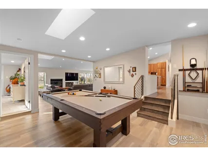 a room with furniture pool table and painting on the wall