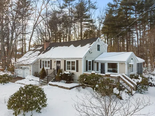 a front view of a house with a yard covered in snow