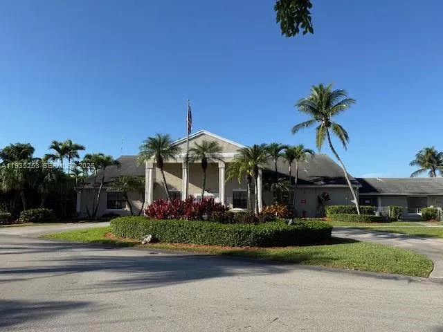 a front view of a house with a yard and potted plants