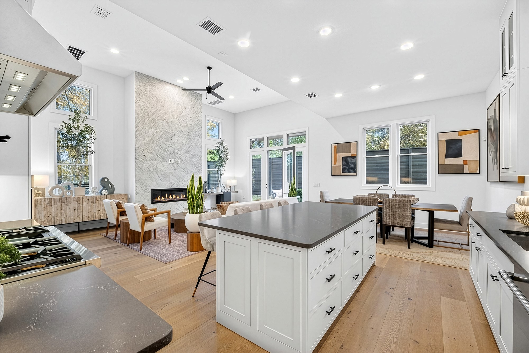 2707 Salek View Austin, TX 78741 - Photo 1 of 39 Kitchen featuring white cabinets, a breakfast bar, custom exhaust hood, a center island, and light wood-style floors