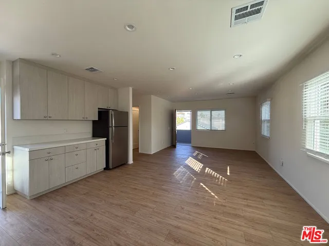 a large kitchen with lot of cabinets and wooden floor