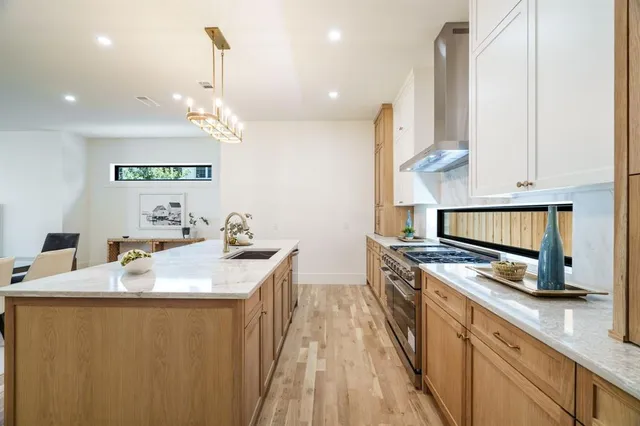 a kitchen with a sink a stove and cabinets