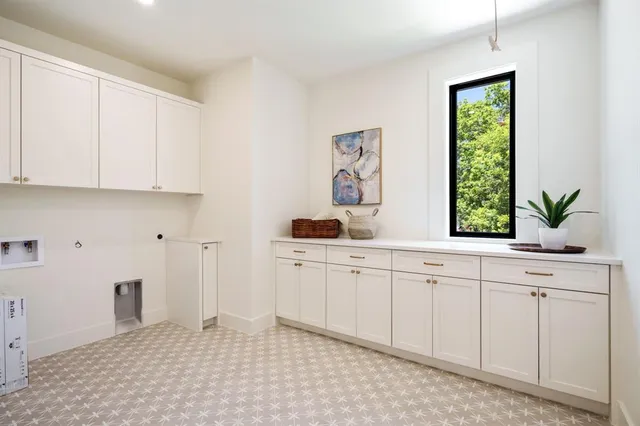a kitchen with white cabinets and window