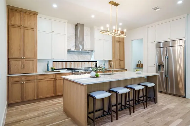 a kitchen with kitchen island granite countertop a sink a center island and stainless steel appliances