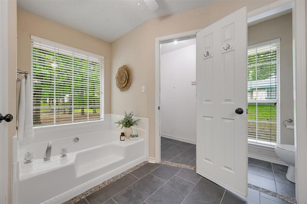 248 Butternut Lane Powderly, TX 75473 - Photo 22 of 40 a bathroom with a bathtub a sink and a window