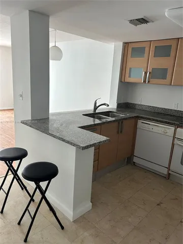 a kitchen with stainless steel appliances granite countertop a sink and a stove
