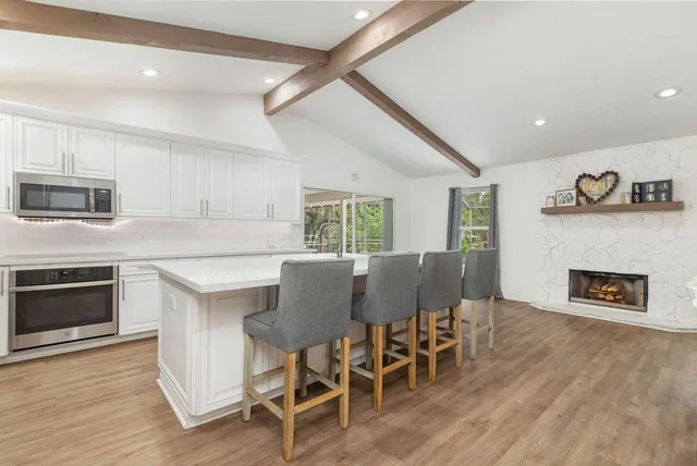 a kitchen with a table chairs refrigerator and microwave