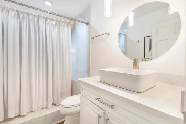 a bathroom with a sink a toilet and a mirror