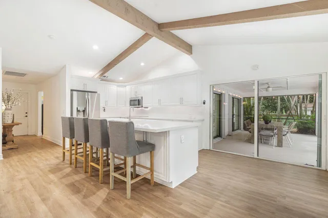 a large white kitchen with chairs and a table