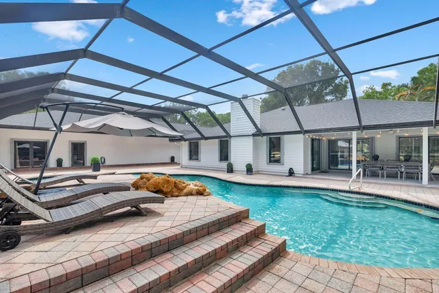 a backyard of a house with yard table and chairs