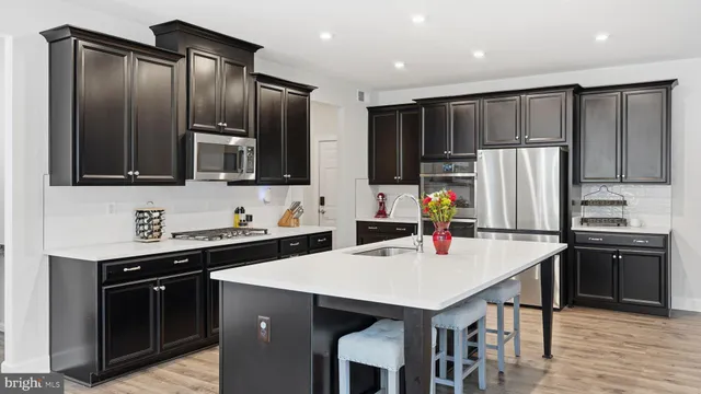 a kitchen with stainless steel appliances a stove refrigerator sink and cabinets