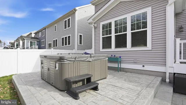 a view of a house with a barbeque and bench